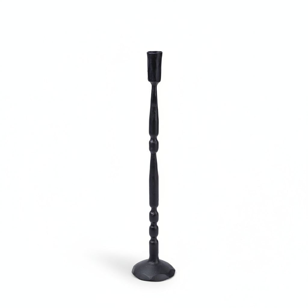 A single black metal candlestick holder with a flared base and a slender, turned stem ending in a cup-shaped top, shown against a plain cream background.
