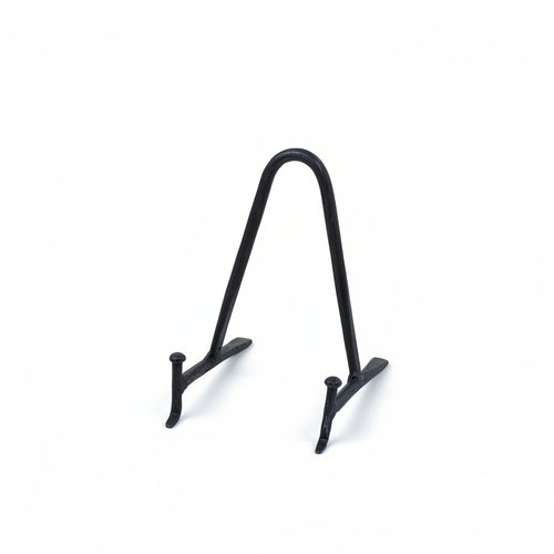 A small black metal display stand with a curved top and two short legs, photographed on a plain warm cream background.